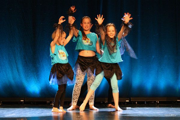 KOlme tyttöä tanssimassa Luova lava konsertissa kesäleirillä
